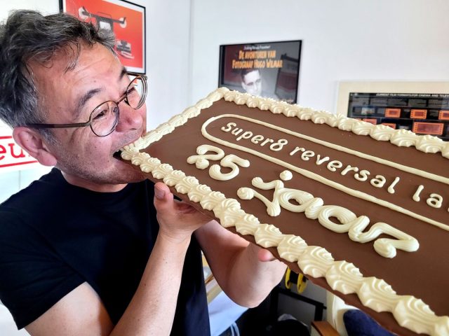 Frank tastes the huge chocolate bar.